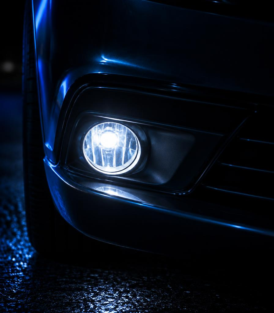 Clear fog light glowing low on a dark bumper